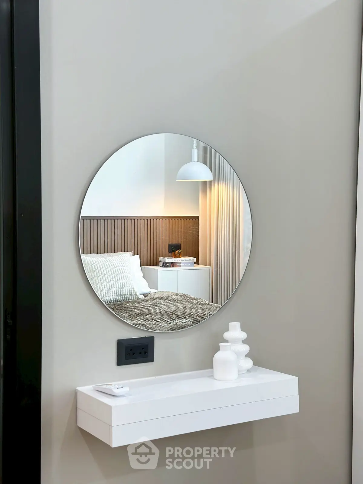 Modern bedroom with round mirror and stylish decor