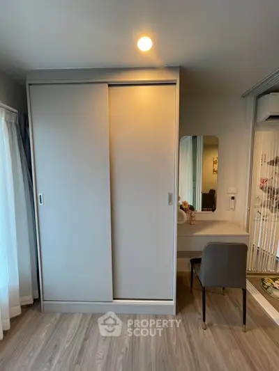 Modern bedroom with sleek wardrobe and stylish vanity area, perfect for contemporary living.