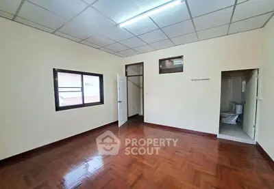 Spacious empty room with wooden flooring and natural light