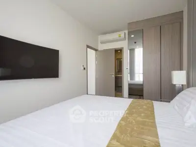 Modern bedroom with wall-mounted TV and stylish wardrobe