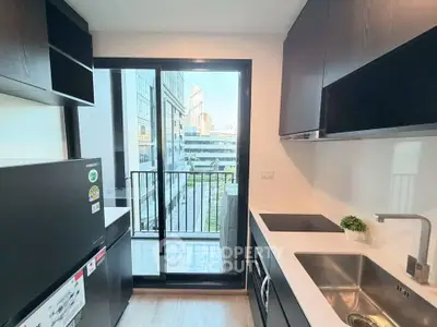 Modern kitchen with sleek cabinets and balcony view in urban apartment