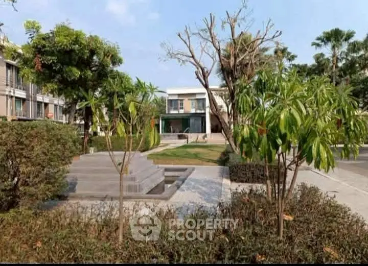 Modern residential building with lush garden and clear blue sky