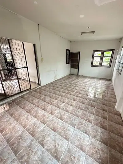 Spacious room with tiled flooring and natural light, ideal for customization.