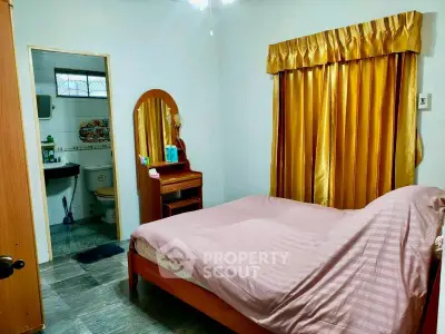 Cozy bedroom with ensuite bathroom and elegant gold curtains