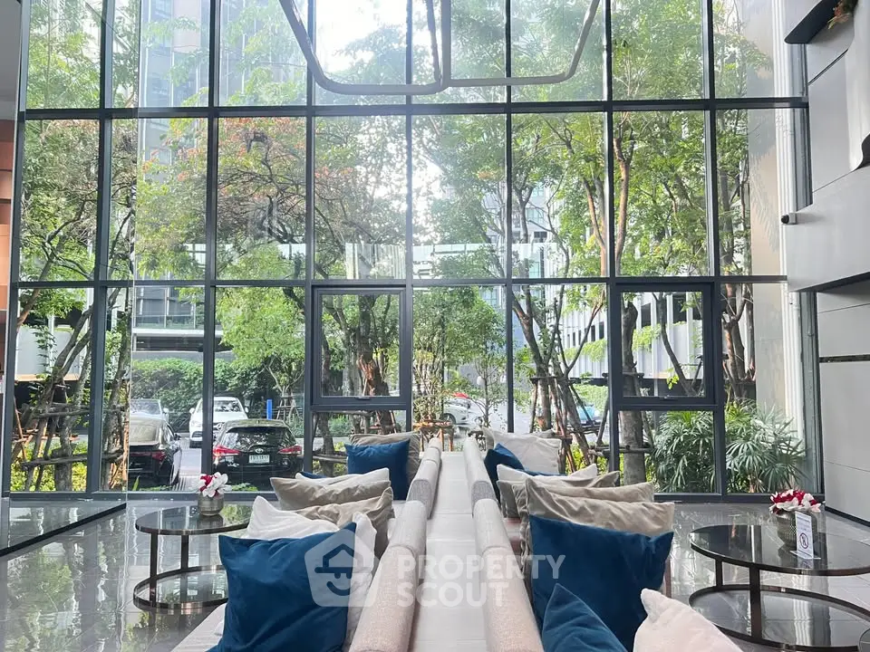 Luxurious lobby with floor-to-ceiling windows and lush garden view