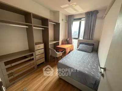 Modern bedroom with city view, featuring sleek furniture and ample storage space.