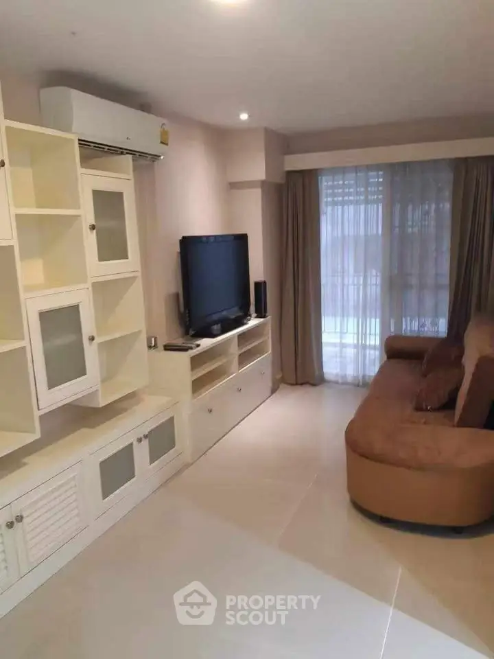 Spacious living room with modern entertainment center and cozy sofa, perfect for relaxation.