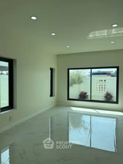 Spacious modern room with large windows and glossy marble flooring