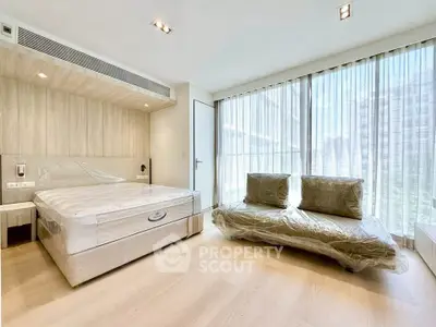 Spacious modern bedroom with natural light and stylish furnishings.