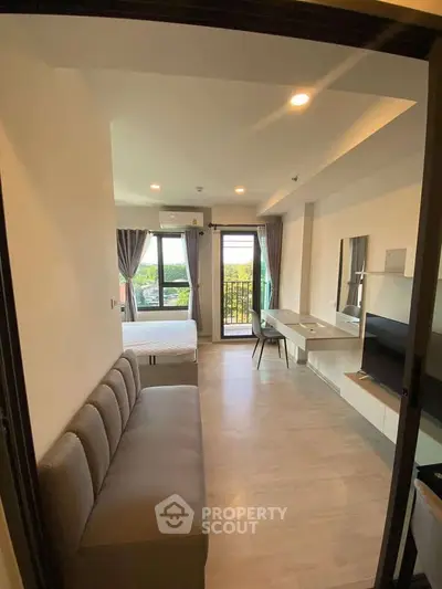 Modern studio apartment with cozy living area and balcony view