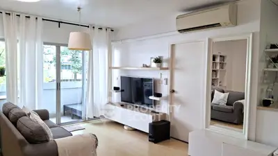 Modern living room with balcony access, featuring sleek furniture and air conditioning.