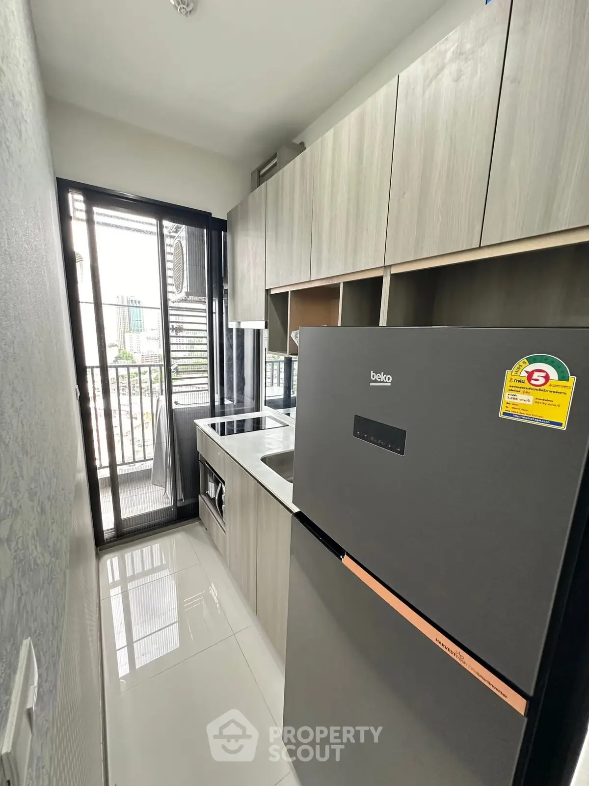 Modern compact kitchen with sleek appliances and balcony access