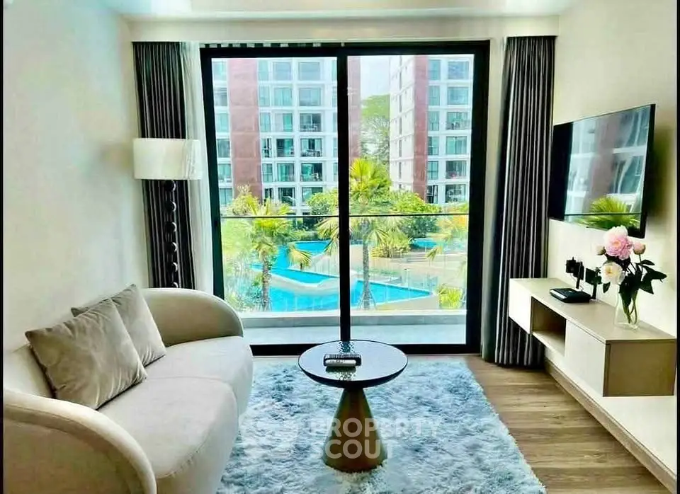 Modern living room with pool view, elegant decor, and natural light in luxury apartment.