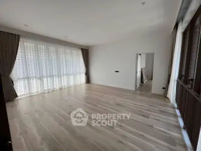 Spacious empty living room with large windows and wooden flooring