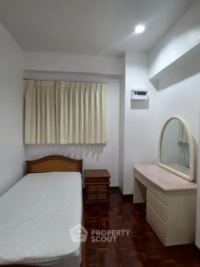 Cozy bedroom with single bed, wooden flooring, and a vanity desk, perfect for a minimalist lifestyle.