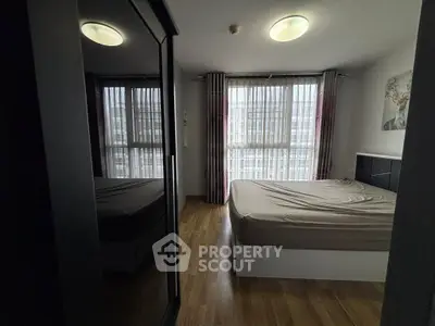 Cozy bedroom with large window and mirrored wardrobe, perfect for natural light lovers.