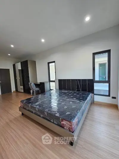 Spacious bedroom with modern design and ample natural light.