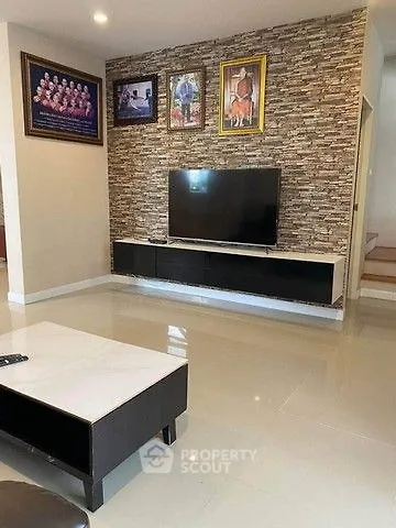 Modern living room with stone accent wall and sleek TV setup
