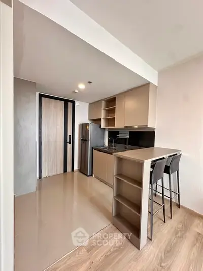 Modern kitchen with sleek cabinetry and breakfast bar in a stylish apartment.