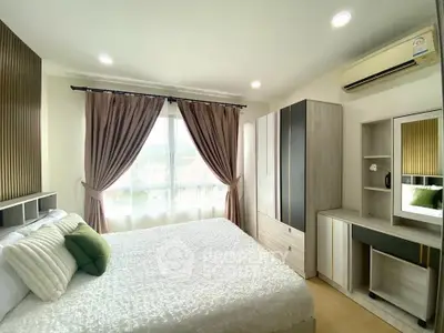 Bright and cozy bedroom with modern furnishings and large window view.
