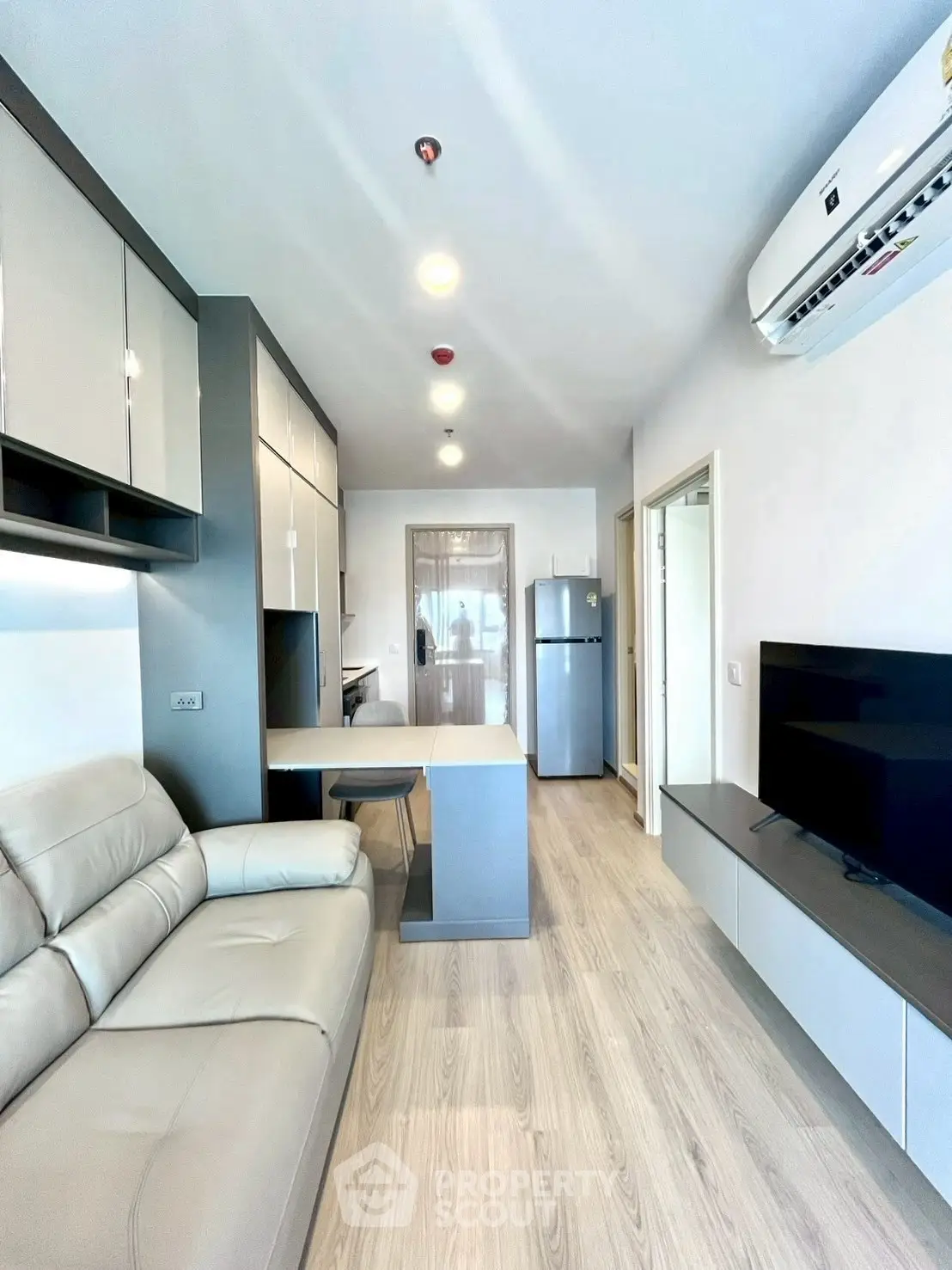 Modern living room with sleek furniture and open kitchen layout in a stylish apartment.