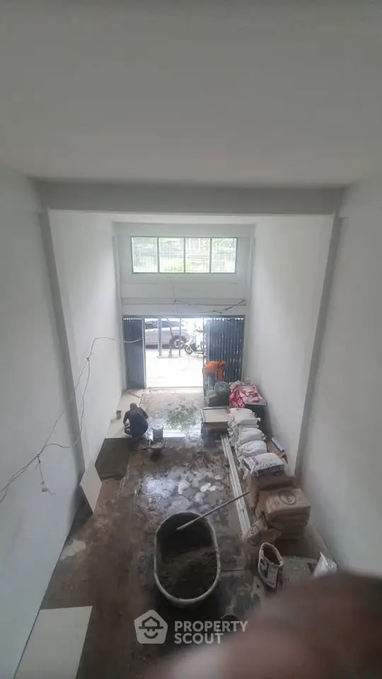Spacious unfinished interior space with high ceiling and large front window, ideal for customization.