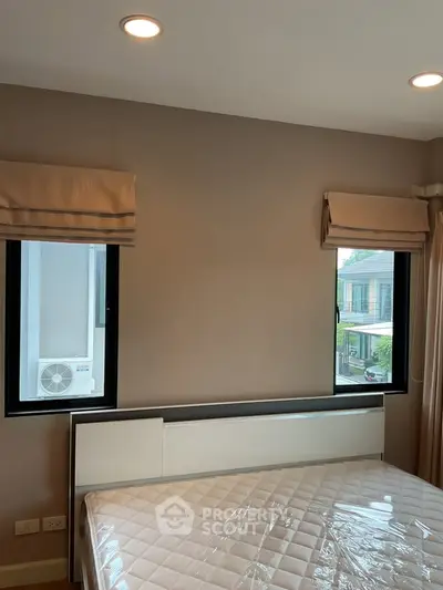 Modern bedroom with large windows and natural light in a stylish home.