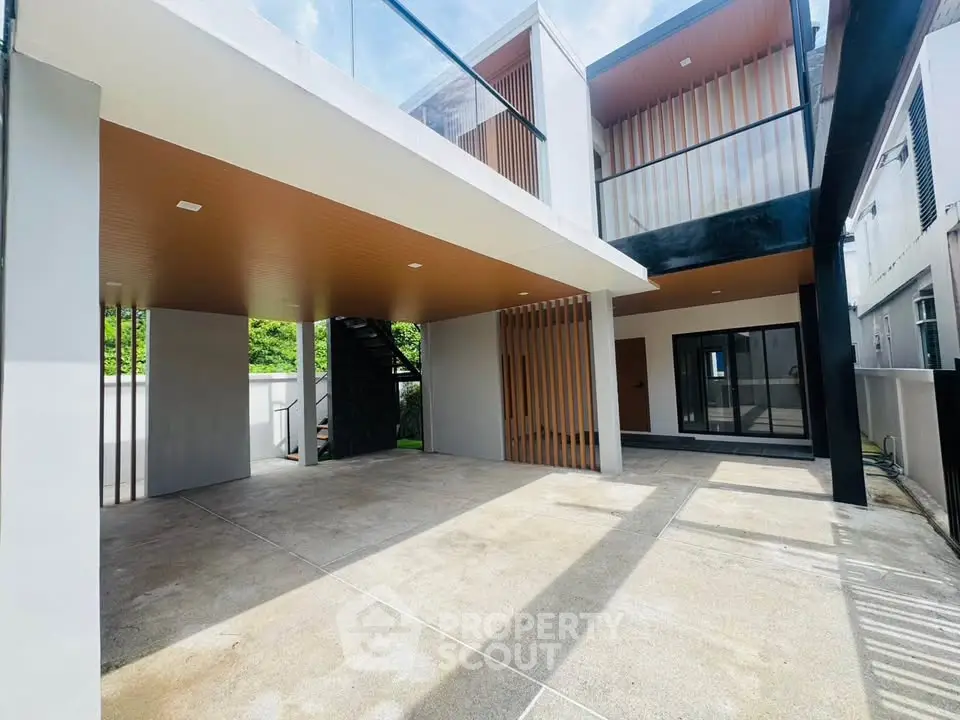 Modern two-story house with spacious driveway and sleek architectural design.
