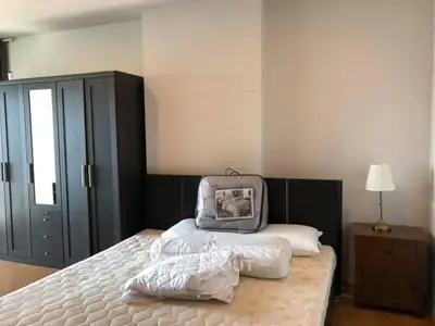 Spacious bedroom with modern wardrobe and cozy bed setup