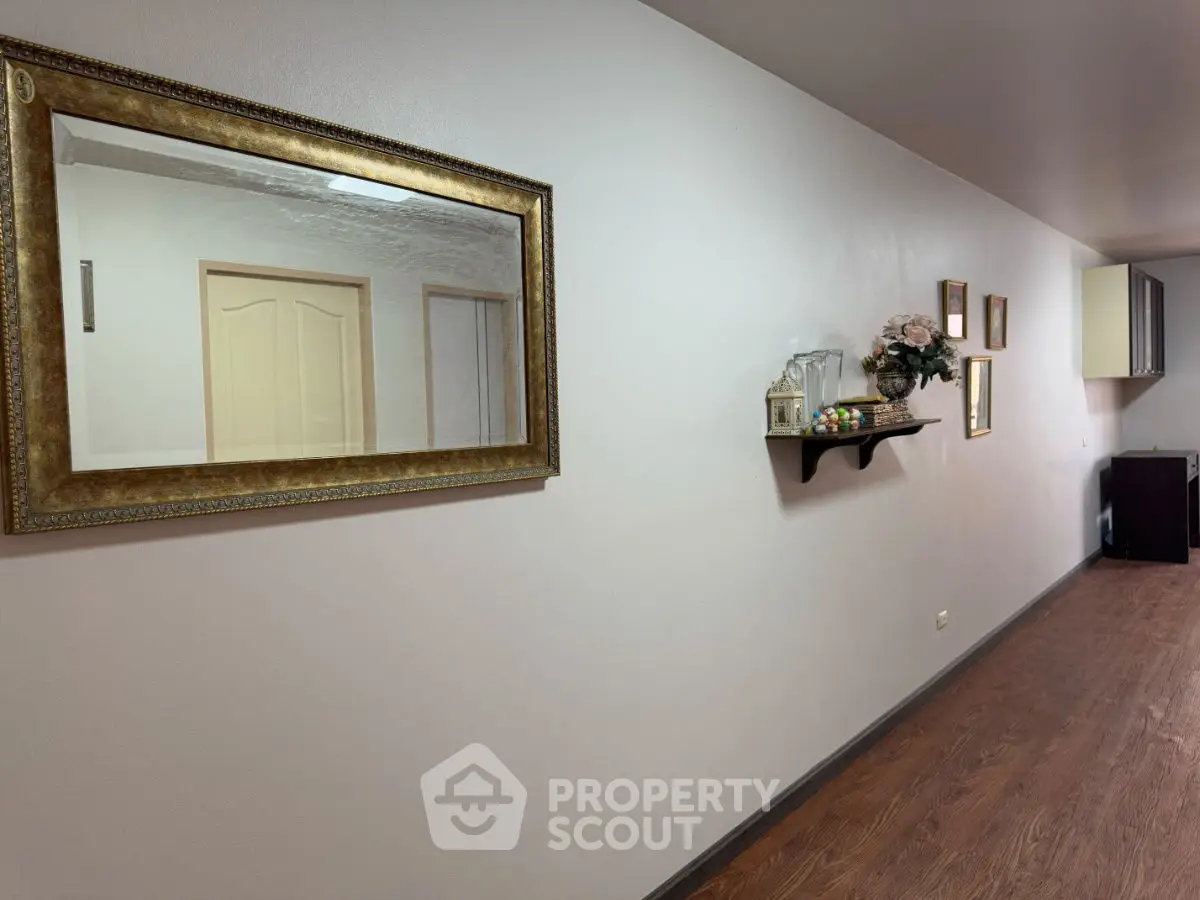 Elegant hallway with decorative mirror and wooden flooring in a modern home.