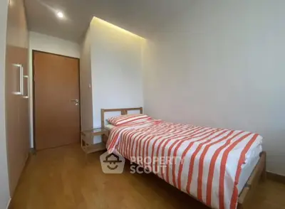 Cozy minimalist bedroom with wooden flooring and striped bedding