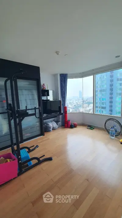 Spacious room with exercise equipment and city view, perfect for fitness enthusiasts.