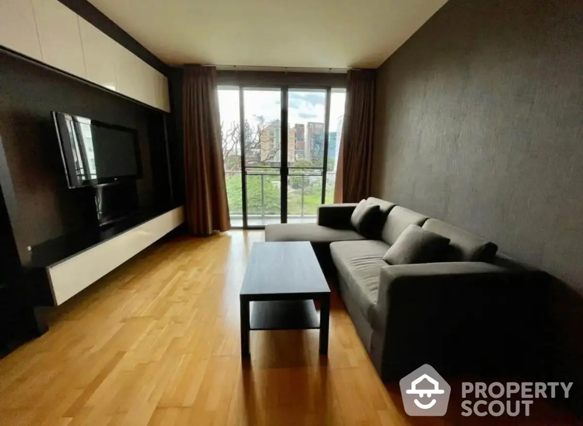 Modern living room with sleek furniture and large window offering a scenic view.