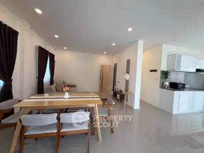 Spacious open-plan living and dining area with modern kitchen in a stylish home.