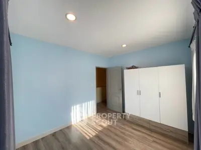 Spacious bedroom with modern wardrobe and natural light