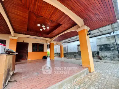 Spacious covered patio with wooden ceiling and tiled flooring