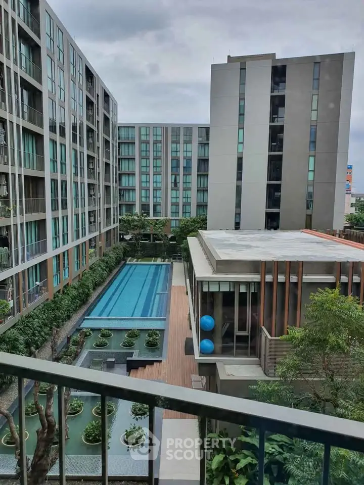 Modern apartment complex with pool and lush greenery, offering a serene urban living experience.