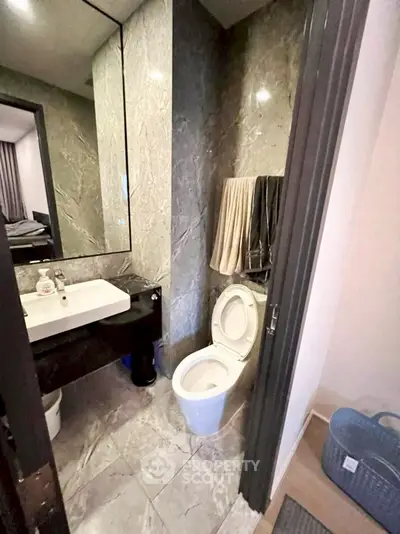 Modern bathroom with marble tiles and sleek fixtures in a stylish apartment.