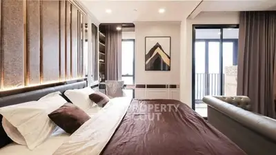 Luxurious bedroom with modern decor and balcony access in upscale apartment.