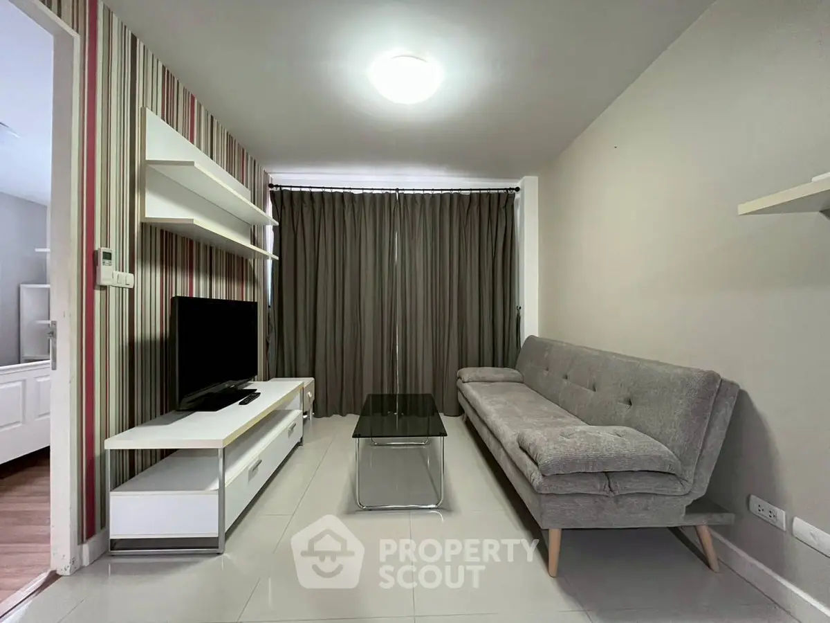 Modern living room with stylish sofa and TV unit in a cozy apartment setting.