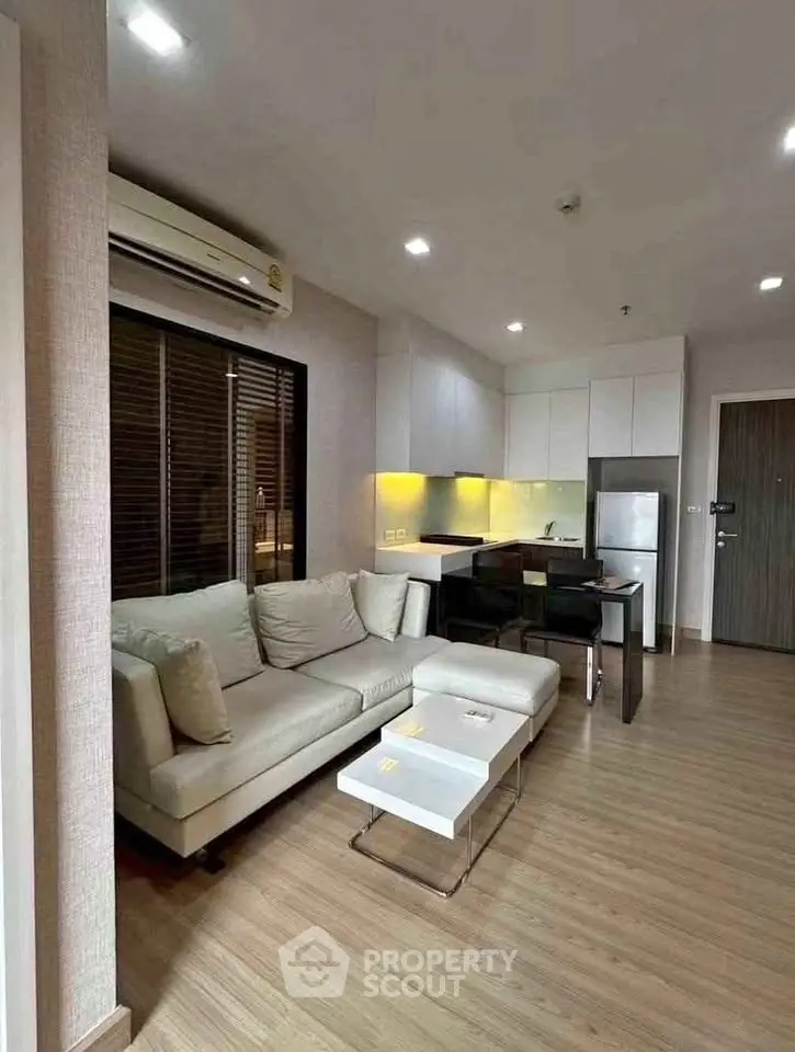 Modern living room with cozy sofa and open kitchen in stylish apartment