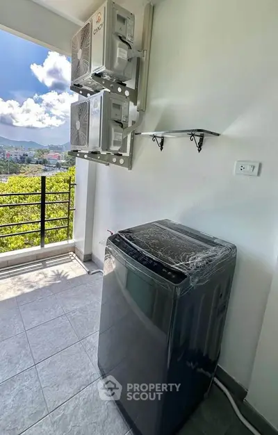 Spacious balcony with washing machine and scenic view, perfect for modern living.