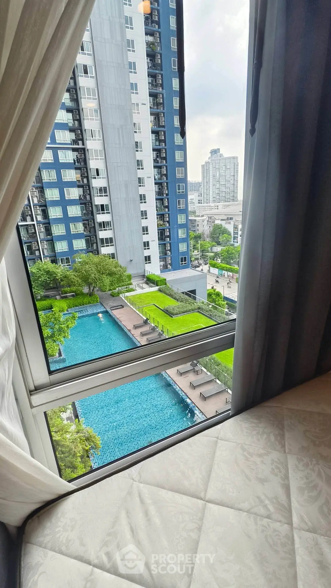 Stunning high-rise apartment view with pool and cityscape, perfect for urban living.