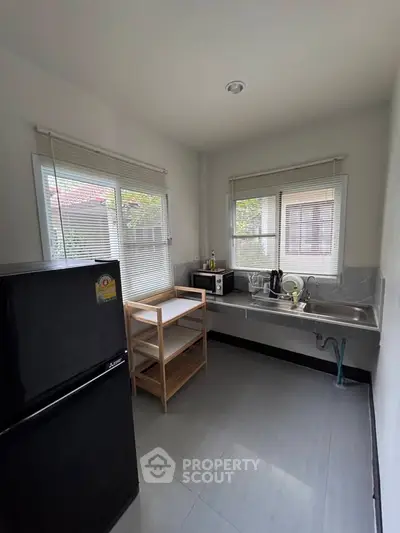 Cozy kitchen with modern appliances and ample natural light, perfect for culinary enthusiasts.