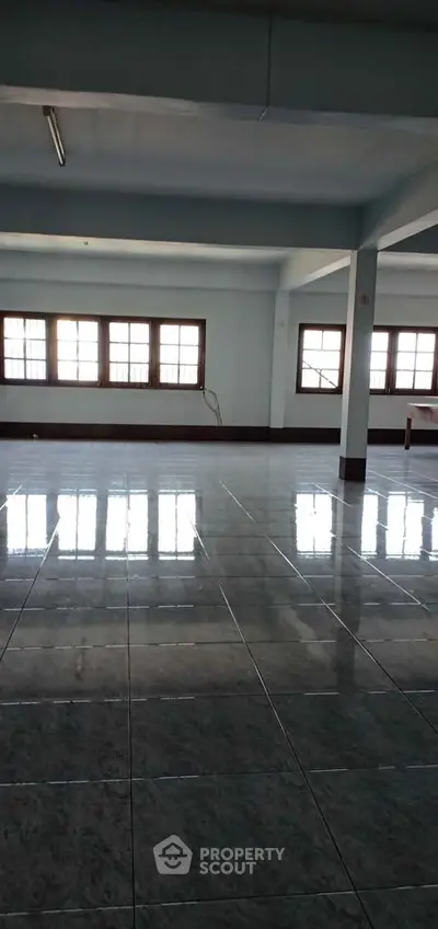 Spacious open-plan interior with large windows and tiled flooring, ideal for versatile real estate opportunities.