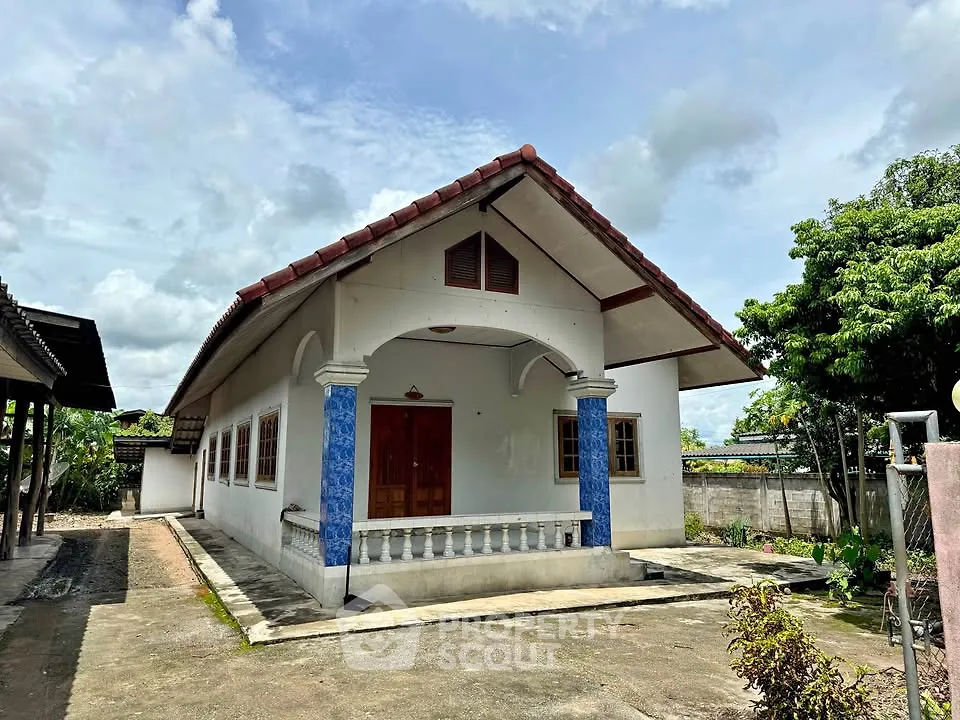Charming single-story house with blue accents and spacious front yard, perfect for family living.