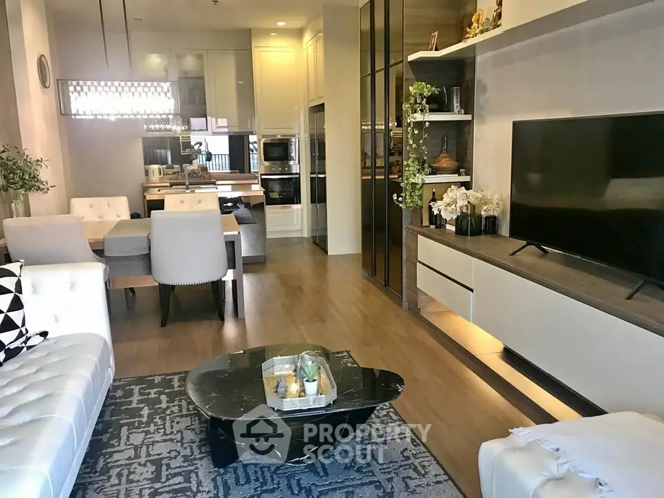 Luxurious modern living room with open kitchen, elegant decor, and stylish furniture in a contemporary apartment.