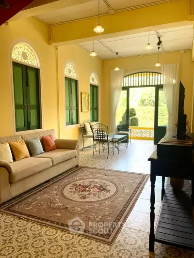 Charming living room with vintage decor and garden view, featuring elegant furniture and natural light.