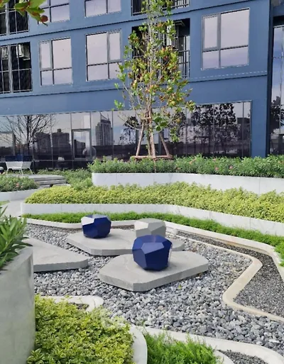 Modern urban garden with unique seating and lush greenery in a residential complex