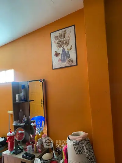 Cozy bedroom with vibrant orange walls and decorative elements.